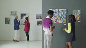 Young multiethnic couple discussing abstract painting while visiting contemporary art exhibition in gallery - Powered by Shutterstock - Get 15% off with code: PIKWIZARD15