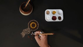 Close-up of a female hand creating an Australian theme inspired style of dot painting. Original artist design - Powered by Shutterstock - Get 15% off with code: PIKWIZARD15