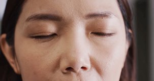 Video close up portrait of the opening eyes of asian female doctor. Hospital, medical and healthcare services.