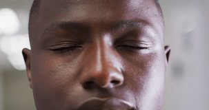 Video close up portrait of the opening eyes of african american male medical worker. Hospital, medical and healthcare services.