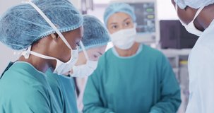 Video of african american female surgeon looking to camera during operation with diverse colleagues. Hospital, medical and healthcare services.