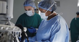 Video of two diverse female surgical assistants preparing electronic equipment in operating theatre. Hospital, medical and healthcare services.