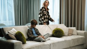 Family conflict with mother and child. Mom shouting yelling at her teenager son. Mom and child quarrel conception. Angry mother scolding a disobedient child. Teenage boy sitting on sofa, mom screaming - Powered by Shutterstock - Get 15% off with code: PIKWIZARD15