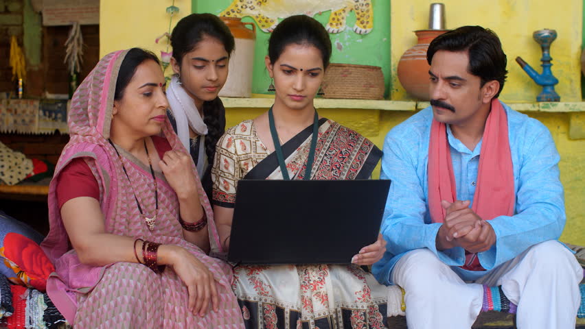 A middle-aged village couple and their teenage daughter with a government official - Use of technology in life. A government employee in a Saree explaining new policies  schemes to a village famil... Royalty-Free Stock Footage #1098850799