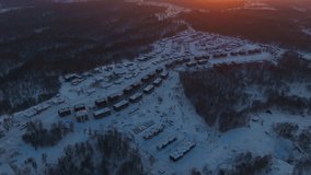 The small village in snowy winter at sunset. Aerial view	