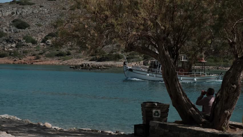 fishing boat sails away from cretan bay