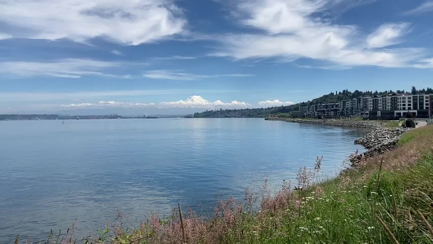 The stunning view of a snowcapped Mt Rainier on a clear day with the urban skyline of Tacoma in the foreground and still, blue waters of Puget Sound - Point Defiance Park, Washington, USA