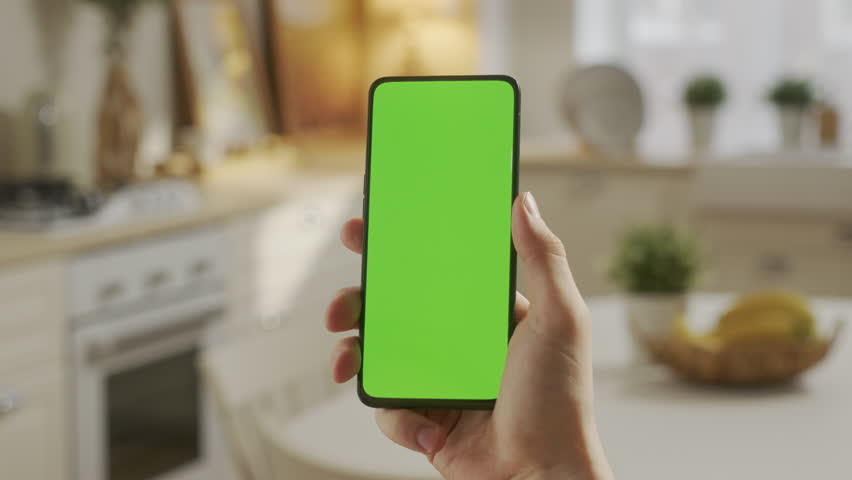 Handheld Camera: Point of View of Man at Kitchen Room Using Phone With Green Mock-up Screen Chroma Key Without Track Points Surfing Internet Watching Content Videos Blogs Delivery. Tapping on Center | Shutterstock HD Video #1098861479