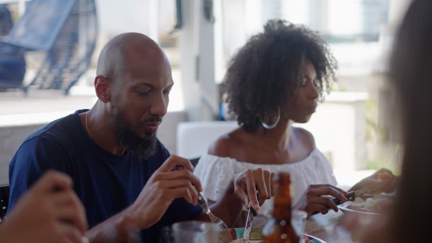 Happy family eating in a traditional brazilian barbecue. Having picanha for dinner. People of different ages spending time together at barbecue.
