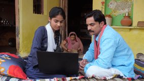 A middle-aged villager and his young daughter using a laptop together - modern Indian villagers. Use of technology in rural India - rural lifestyle, Indian nuclear family, education girl in Indian ... - Powered by Shutterstock - Get 15% off with code: PIKWIZARD15