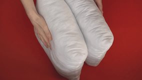 a man checks the elasticity of white pillows on a red table. High quality Full HD video recording