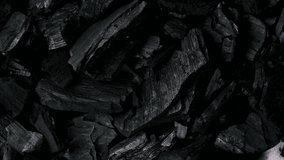 Black background of heap natural charcoal mineral used in industry and food preparation rotate. - Powered by Shutterstock - Get 15% off with code: PIKWIZARD15