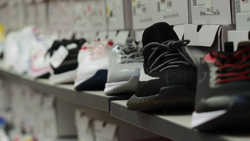Athletic shoes on the shelf in the store.A man chooses athletic shoes.