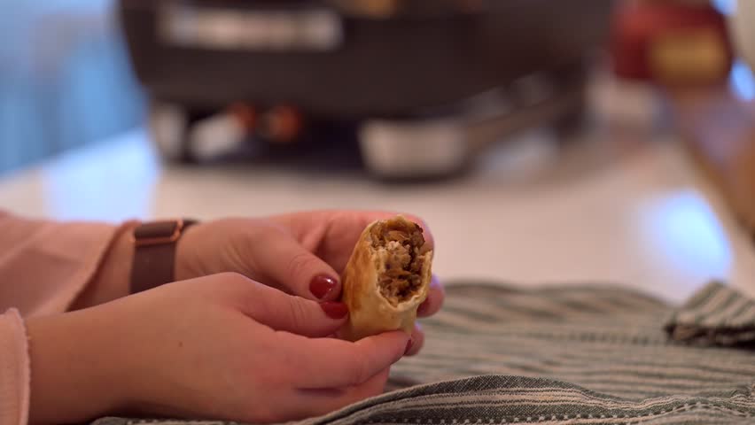 A woman cooking an eggroll burritos
