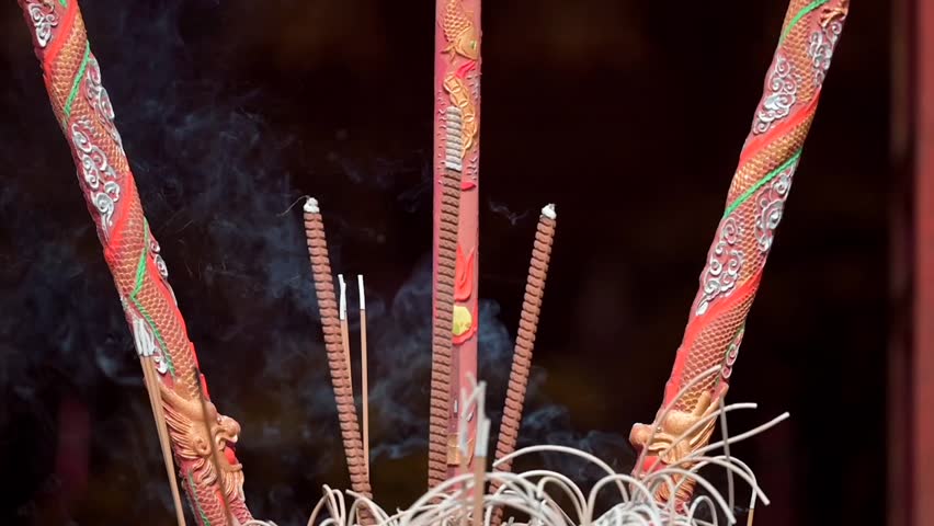 A closeup of incense burning at the altars in Ngoc Son Buddhist Temple in Hanoi, Vietnam