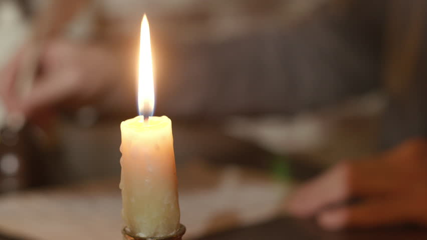 A burning candle is the focus of this 1790s scene of a man in the background writing with a quill pen. Royalty-Free Stock Footage #1098898357
