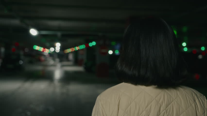 Back rear view from behind brunette with short hair woman walk at parking lot. Elegance lady girl customer client female businesswoman walking at mall underground in darkness moving hurry to meeting Royalty-Free Stock Footage #1098898787