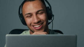 Close-up young latin american man on gray background talking video call on laptop using headset friendly businessman consultant call center operator work in helpline advise client at online conference - Powered by Shutterstock - Get 15% off with code: PIKWIZARD15