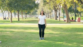 Indian woman doing jumping jacks exercise in a park in morning - Powered by Shutterstock - Get 15% off with code: PIKWIZARD15