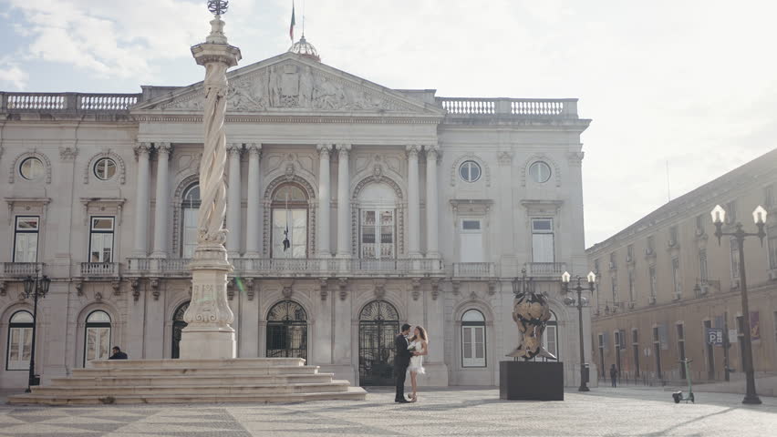 Romantic date in the city historical center. Action. Man and woman in front of beautiful buildings on a summer day.