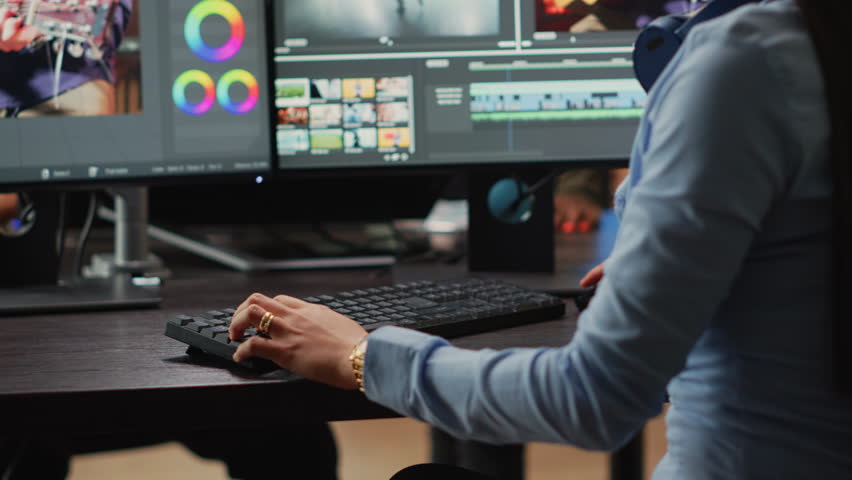 Young content creator editing video and audio montage on computers, creaating movie with professional studio footage. Female videographer using color grading to edit clips in post production agency. Royalty-Free Stock Footage #1098907935