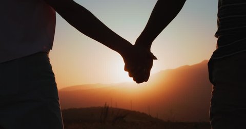 Silhouette of couple holding hands at sunset. Romantic couple in love, support each other concept. Closeup slowmotion 庫存影片