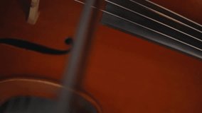 Playing with a bow on the cello, medium plan, vertical video
