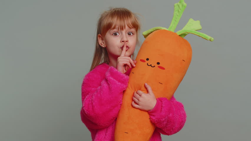 Shh be quiet please. Preteen child girl kid presses index finger to lips makes silence hush gesture sign do not tells gossip secret. Little toddler children isolated alone on studio gray background