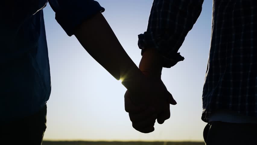 Separation of hands of man of woman. Family at sunset. Pair of man, woman separate their hands in front of sun. Closeup of guy lets go of girls hand, separation. Separation, separation, quarrel. Royalty-Free Stock Footage #1098916193