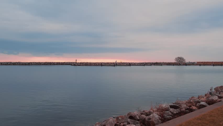 Milwaukee breakwater light, captured at sunrise, historical landmark in Wisconsin, cinematic shot. aerial flying low above water Lake Michigan