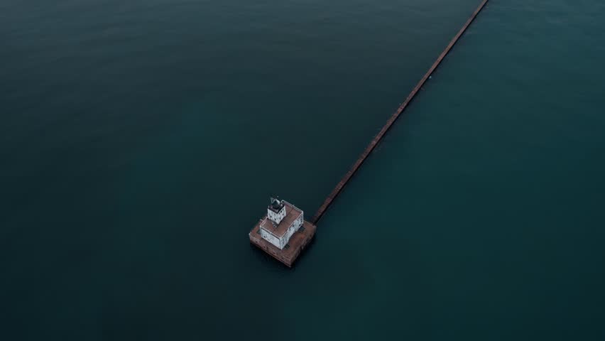 cinematic revealing of milwaukee behind Milwaukee breakwater light. Complex aerial shot 4k. Orange Milwaukee bridge