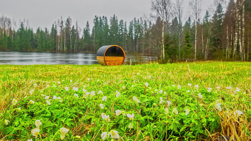 Time Lapse View Of Wooden Gazebo Beside Lake With Heavy Snow Falling And Then Slowly Melting. Low Angle, Static Shot