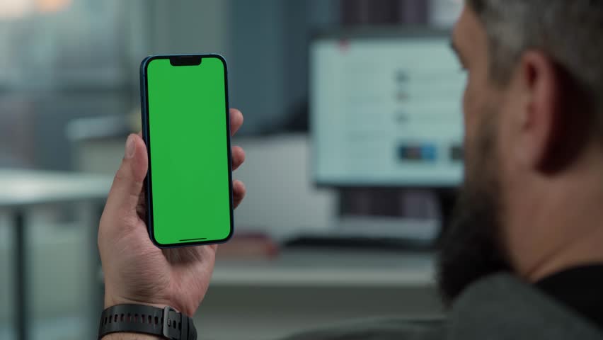 Close Up of Smartphone with Green Screen Mock Up Display In Male Hands. Man Sitting In Office Browsing Internet , Watching Content, News, Financial Reports on Phone | Shutterstock HD Video #1098926351