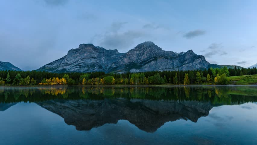 Time lapse of Wedge pond with rocky mountains and pine forest in autumn season at Kananaskis country, Alberta, Canada