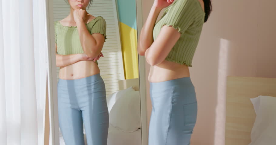 close up view - asian woman standing in front of mirror and dissatisfied about her body shape Royalty-Free Stock Footage #1098930263
