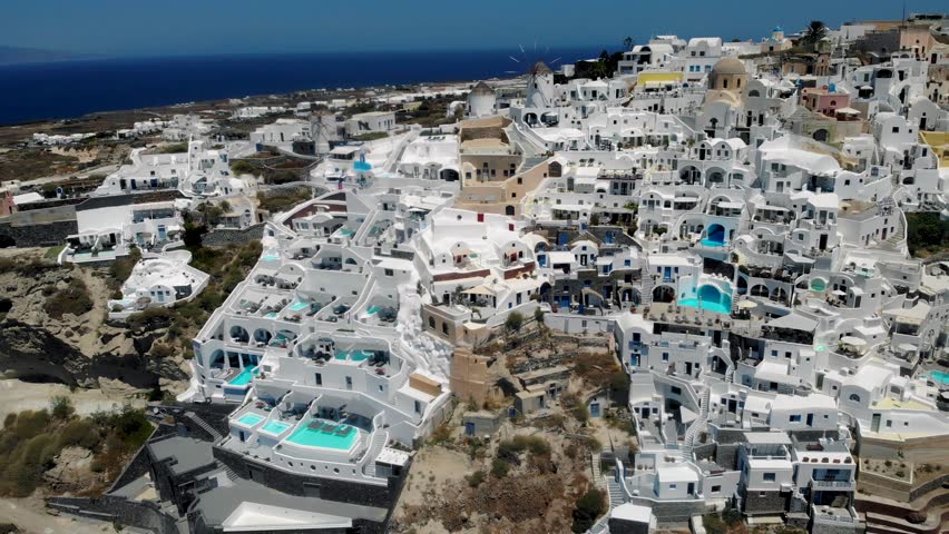 Oia village Santorini with whitewashed house and swimming pools during sunset at the Island of Santorini Greece Europe,