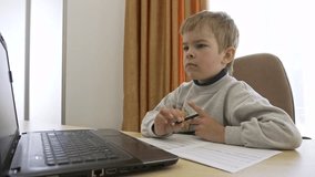Little Boy Distance Remote Study Online Music at Home Sitting at Desk. Slow motion 4K
