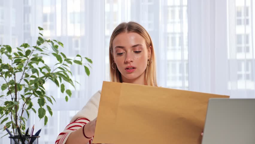 Sad worried woman sitting at the table reads received bad news, holds documents paper letter feels desperate about financial problems or debt, girl student reads letter of expulsion from the college. Royalty-Free Stock Footage #1098936335