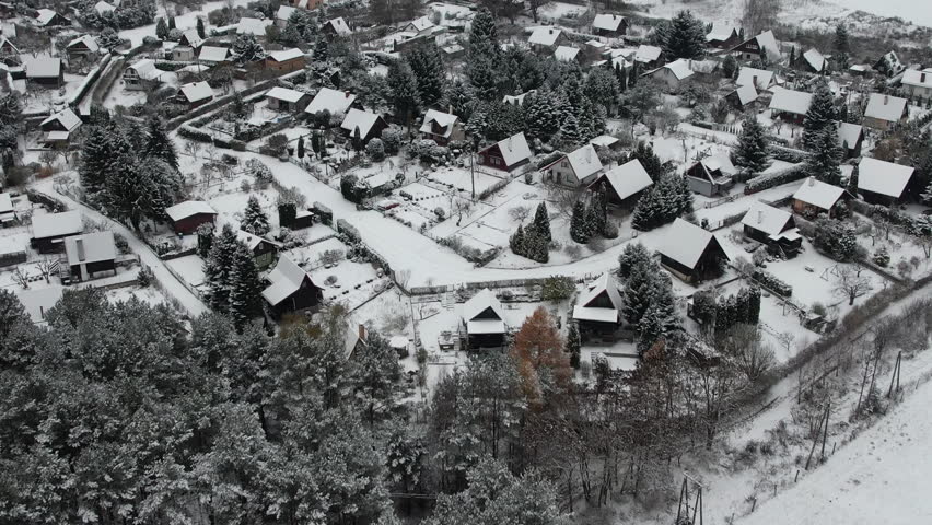 Aerial View Peaceful Small Town Under Deep, Fresh Snow, Early in Winter. Countryside Village Rooftops During Heavy Snowfall. Suburb Residential Neighborhood Winter Day. Europe Poland.