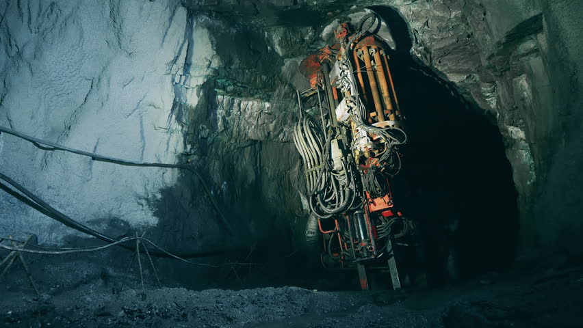 Boring machine is drilling ground in the mine. Underground development, underground extraction, underground mining operations.
