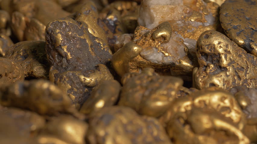 Small gold nuggets collected at the natural resource ore mine. Lots of gold material pieces gathered from the natural resource deposits. Precious natural gold metal resource found in quarry Royalty-Free Stock Footage #1098941263