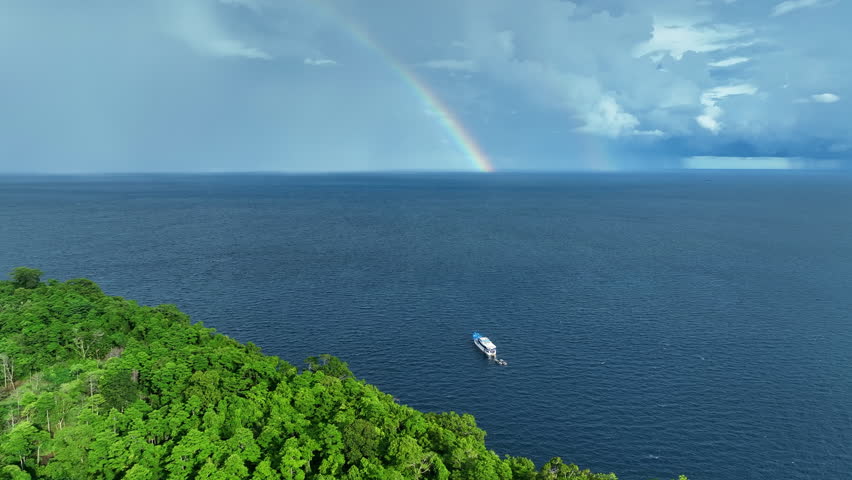 A beautiful rainbow appears near a lush, tropical island in the Solomon Islands. This South Pacific country is known for its spectacular marine biodiversity and its many historic World War II sites.