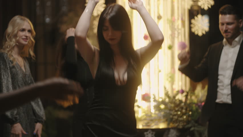 Attractive woman in black dress dancing seductively in company party in New year or Christmas night | Shutterstock HD Video #1098943953