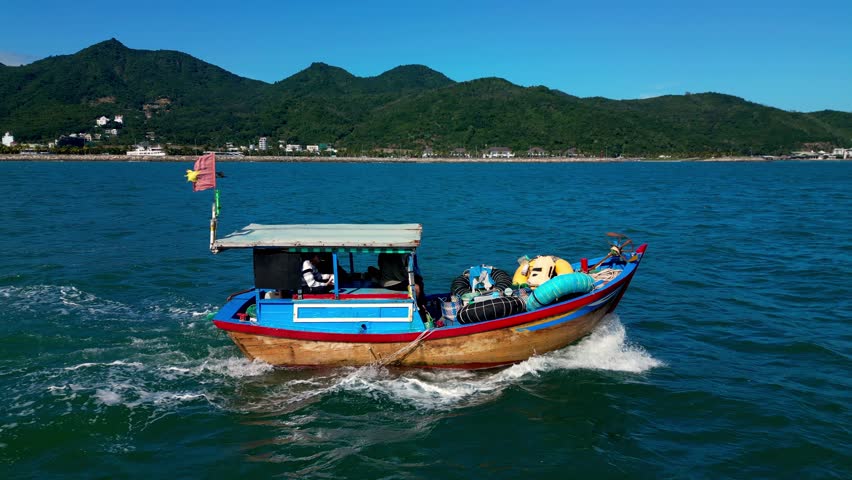Fisherman come out of the boat bay. On a sunny morning, a fishing boat hurries out to sea for a catch of seafood. Asian fishing boats.The fisherman town of Nha Trang in Vietnam.