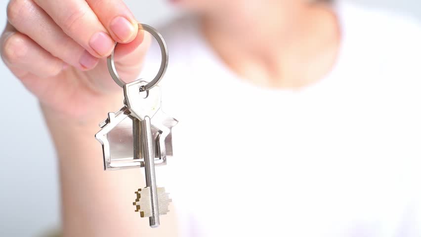 Close up of man holding key with house keychain in hand and walking in new apartment with cardboard boxes and ladder on background. Guy moving in new home. Buying or renting real estate concept Royalty-Free Stock Footage #1098944511