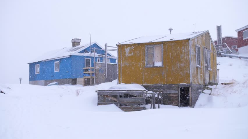Slow motion video of yellow and blue houses in a snowstorm in Ilulissat, Greenland