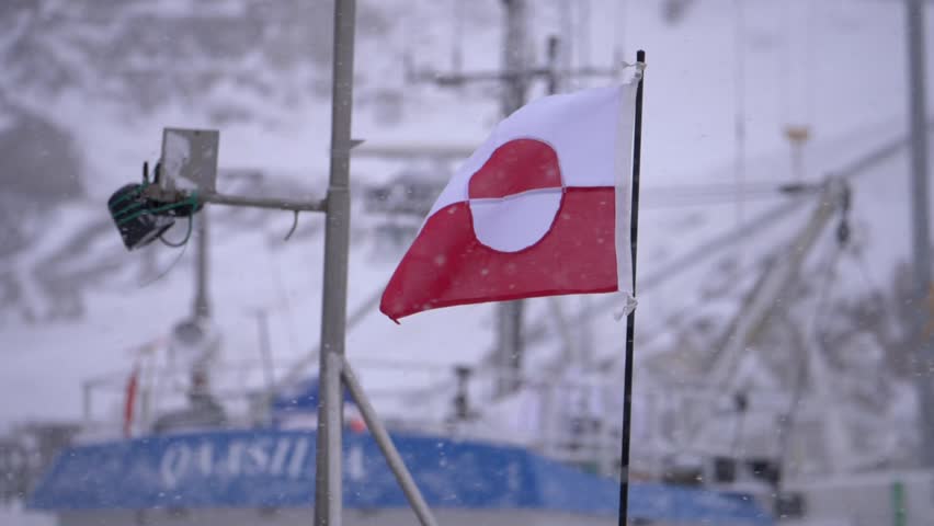 Greenland flag on a boat mast fluttering in a snowstorm in slow motion
