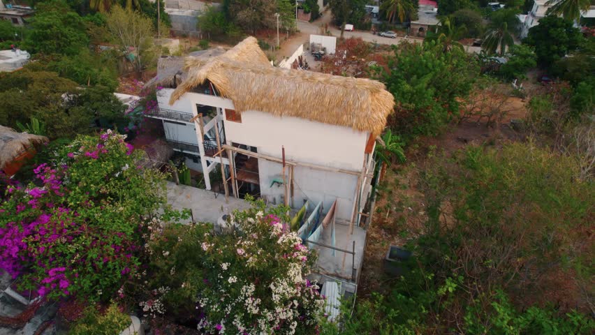 Spiral aerial shot of a hut in Puerto Escondido, Oaxaca México during sunset. 