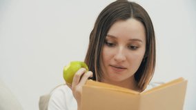 4k slowmotion video of pregnant woman looking at the camera and holding apple and book.
