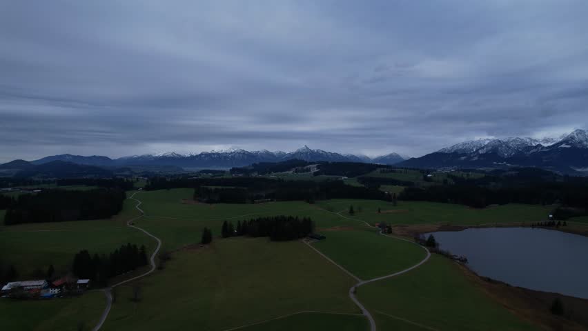 DRONE AERIAL FOOTAGE: Winter view from the Allgau Alps mountain range in the Northern Limestone Alps and alpine lake Attlesee, located near Nesselwang town, Bavaria, Germany.